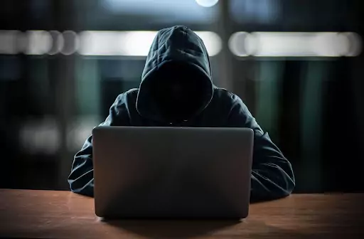 person in black hoodie using laptop